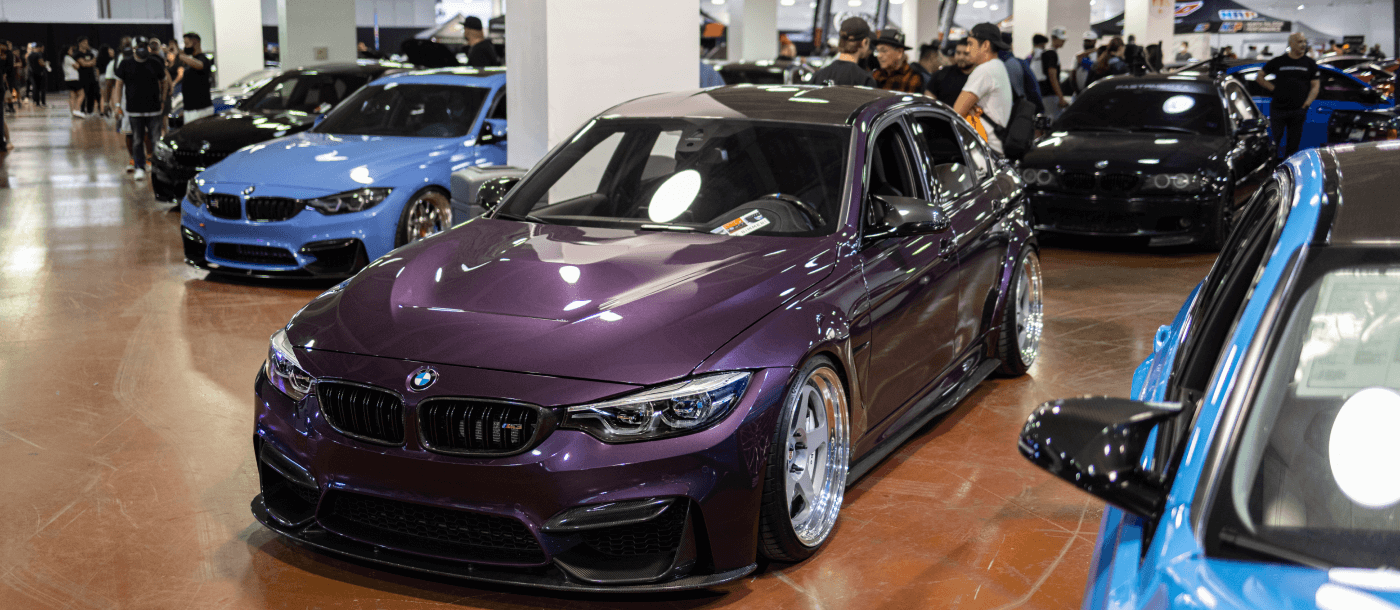 pink M3 in front of auto museum